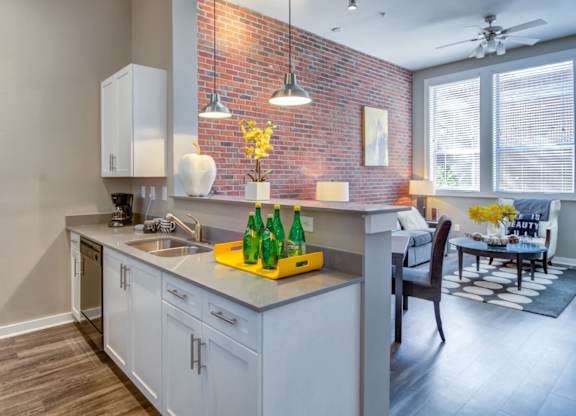 Atlanta, GA Apartments - Biltmore at Midtown - Luxury Kitchen with Exposed Brick Wall