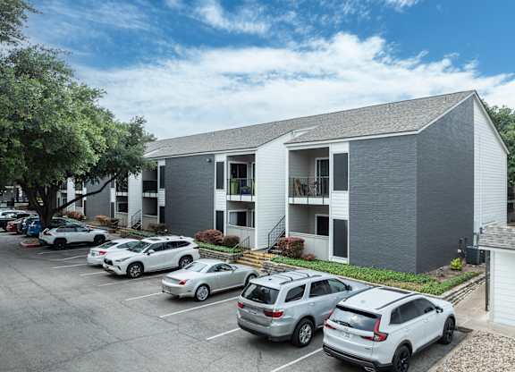a gray building with cars parked in front of it