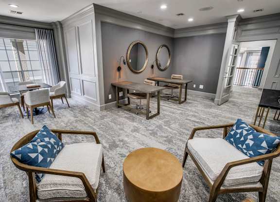 A living room with a grey carpet and wooden furniture.