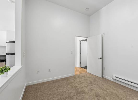 A room with a carpeted floor and a doorway leading to another room.