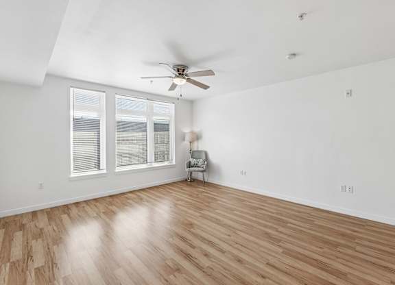A room with a ceiling fan and a chair.
