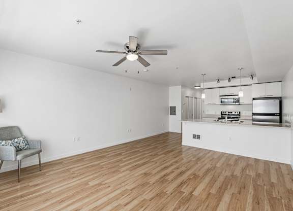 A room with a ceiling fan and a chair with a cushion on it.