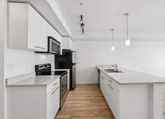 A modern kitchen with white cabinets and appliances.