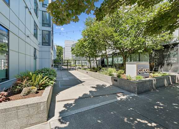 A modern building with a landscaped courtyard in front.