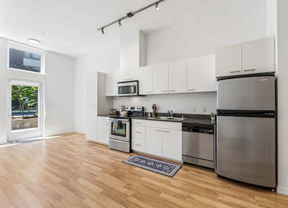 A kitchen with white cabinets and stainless steel appliances.