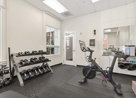 a gym with exercise equipment and dumbbells on the wall