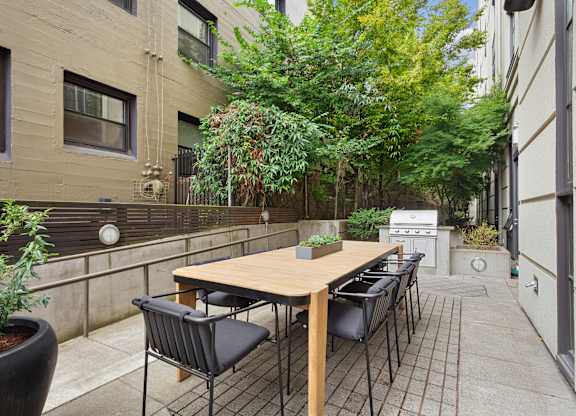 the outdoor patio has a table and chairs and a grill