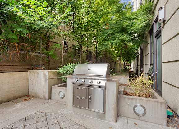 a backyard with a stainless steel grill on the side of a house