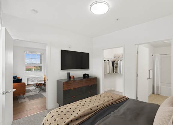 a bedroom with a bed and a tv on the wall