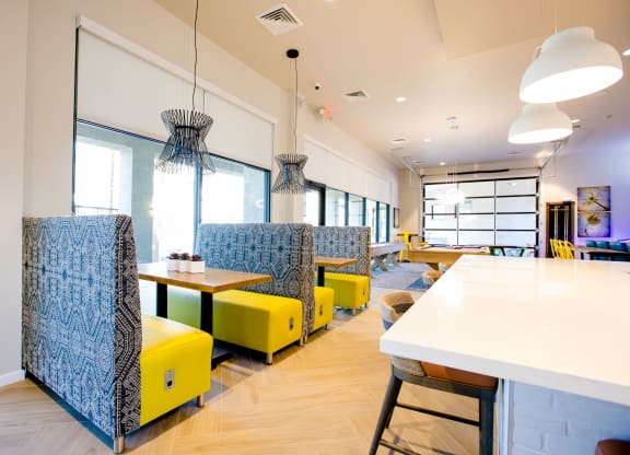 a seating area with yellow chairs and tables in a restaurant