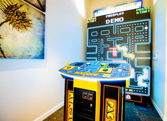 an arcade game in a room with a poster on the wall