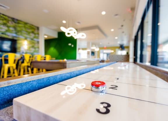a shuffleboard table in a restaurant with three numbers on it