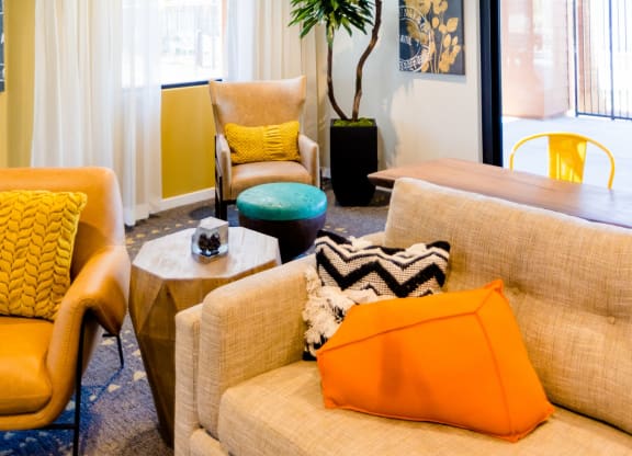 a living room with yellow walls and orange and blue furniture