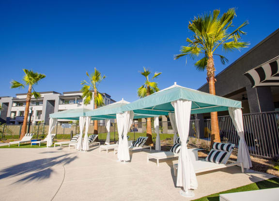 a patio with hammocks and umbrellas at the resort