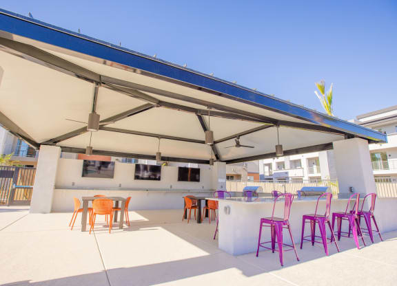 a patio with chairs and a bar and a roof