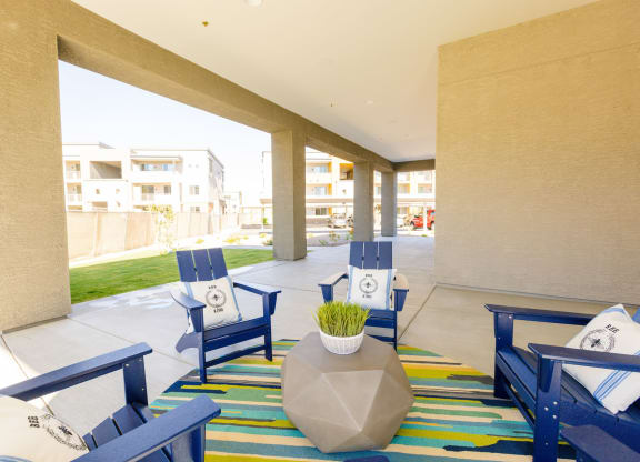 the lobby of a hotel with blue chairs and a colorful rug