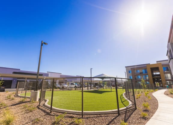 a tennis court in front of a building with a fence