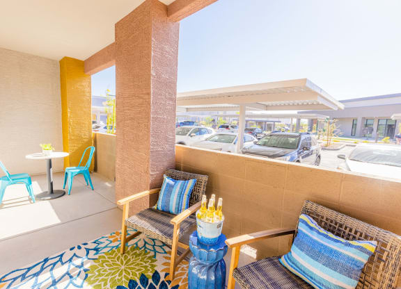 a patio with two chairs and a table and a parking lot