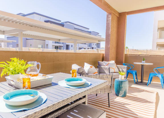a furnished patio with a dining table and chairs