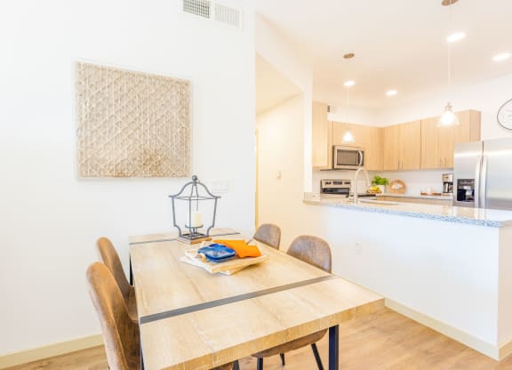 a dining room table with a kitchen in the background