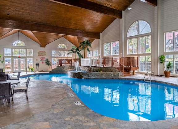 a large swimming pool in a building with large windows