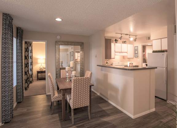 a dining room and kitchen with a table and chairs