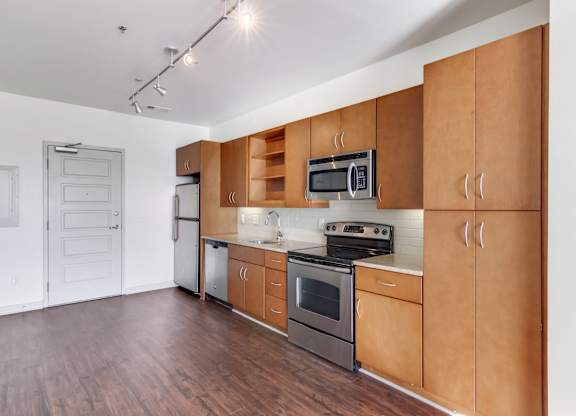 Pet Friendly Apartments in Nashville, TN - 12 South Apartments - Kitchen area with cabinet space, stainless steel appliances, open concept wood-style flooring.