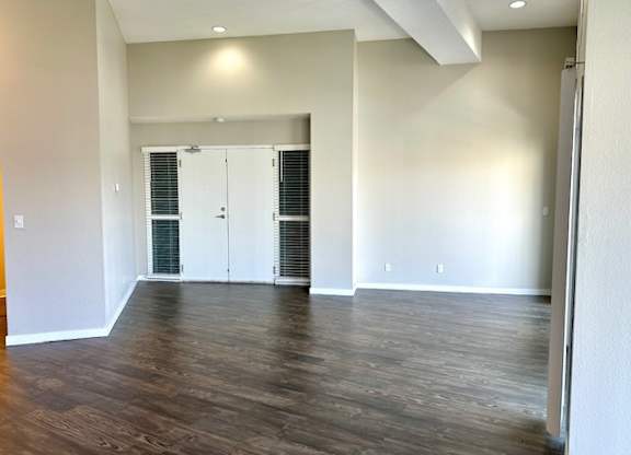 an empty living room with white walls and wood floors