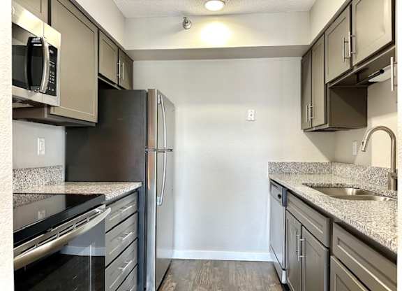 a kitchen with granite counter tops and stainless steel appliances