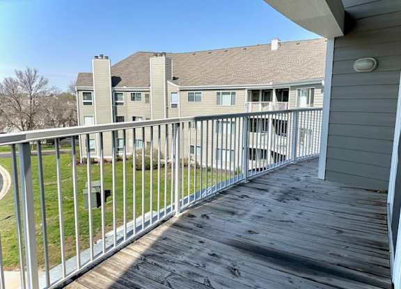 a view of a house from a balcony with a wooden deck