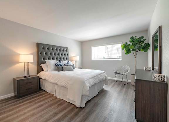 San Clemente, CA Apartments for Rent - Rancho Del Mar - Furnished Bedroom with Hardwood-Inspired Flooring, Stylish Decor, and a Window