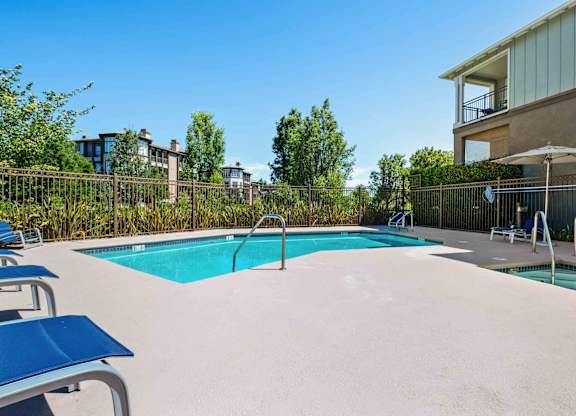 Swimming Pool With Spa and Blue Lounge Chairs