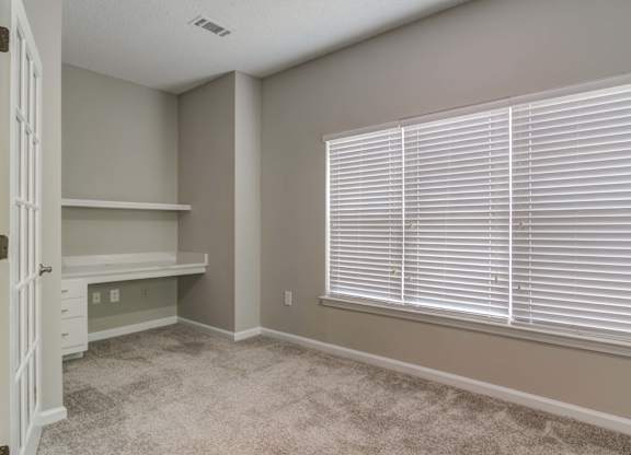 Woodstock, GA Apartments – Lea Woodstock – bedroom with plush carpeting, large windows, and built in desk.