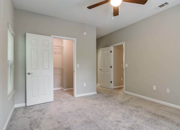 Apartments In Woodstock for Rent – Lea Woodstock – bedroom with plush carpeting, ceiling fan and a view of the closet