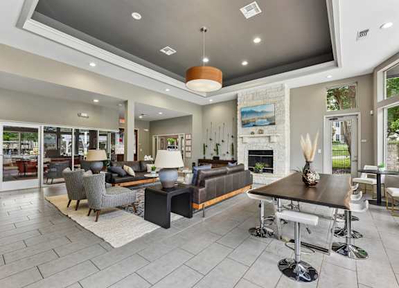 A modern living room with a stone fireplace and a large dining table.