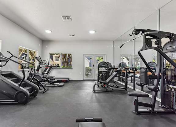 A spacious gym with treadmills, elliptical machines, and other exercise equipment.