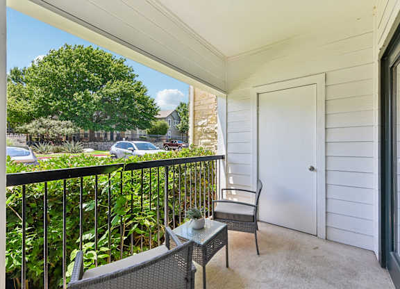 A balcony with a chair and table.