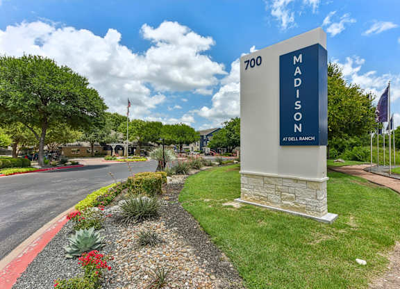 A sign for Madison at Dell Ranch stands in front of a landscaped area.