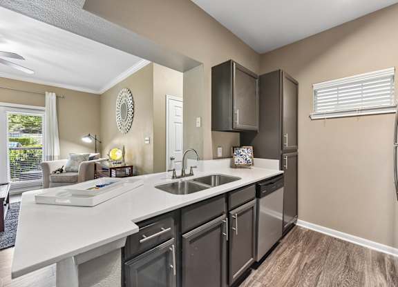 A kitchen with a white counter top and black cabinets.