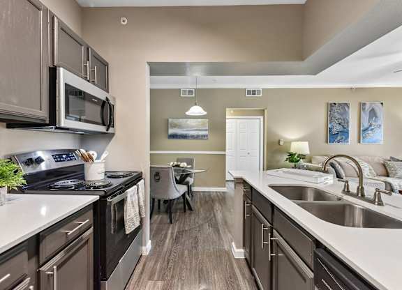A kitchen with a black stove top oven and a black microwave.