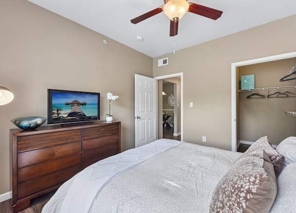 A bedroom with a large bed and a ceiling fan.