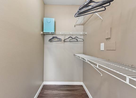 A small closet with a shelf and a hanger rack.