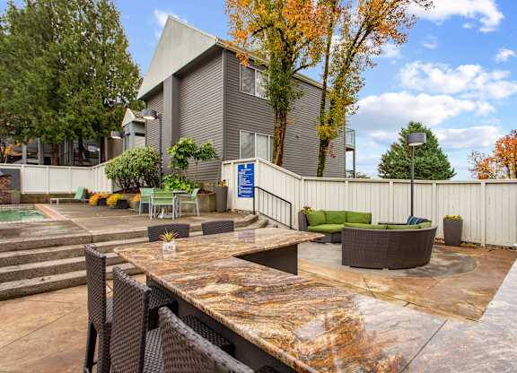 A patio area with a table and chairs in front of a building.