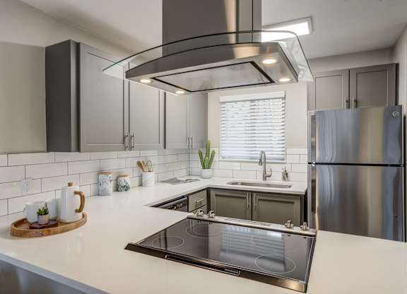 Apartments For Rent In Mountain Park, OR - MiLO - Modern Kitchen With Grey Cabinets, Stainless-Steel Appliances, Quartz Countertops, and Window.