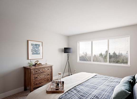 Mountain Park Apartments - MiLO at Mountain Park - Spacious Bedroom with Large Window, a Bed, Double Nightstands, and Carpet.