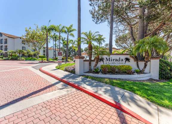 the entrance to mira la quinta apartments with palm trees