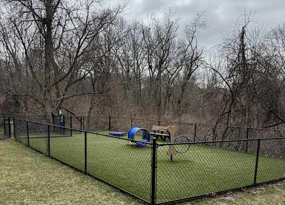 A black fence encloses a green net and a blue object.