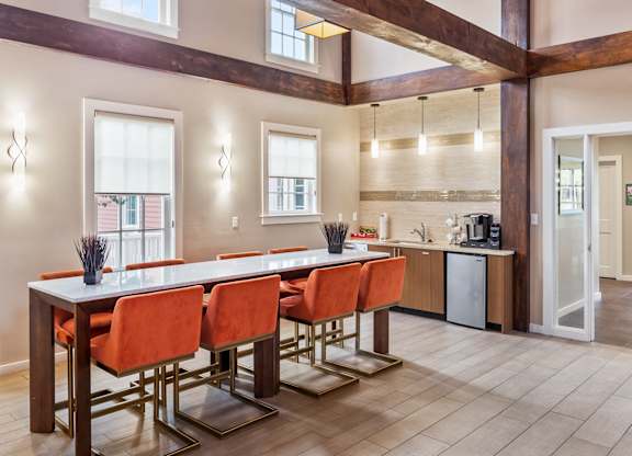 Orchards Apartments Marlborough ma apartment loft style apartments photo of clubhouse lounge with long bar table with bar stools and exposed beams in open floor plan with multiple windows