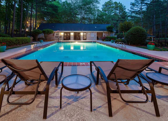 Pet-Friendly Apartments in Alpharetta, GA – Webb Bridge Crossing – swimming pool at dusk with patio chairs