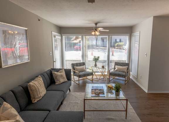 Apartments in Alpharetta, GA for Rent – Webb Bridge Crossing – living room with a couch and two chairs, hardwood floors, ceiling fan and large windows